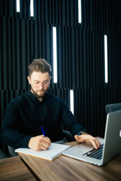 Hombre de negocios barbudo guapo trabajando en un proyecto en un escritorio de oficina moderno — Foto de Stock