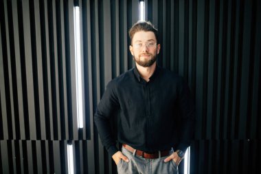 Genç yakışıklı adam modern ofis ayakta sakallı