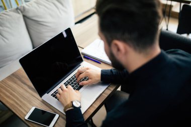 Laptop ile işyerinde çalışan genç iş kişi adam