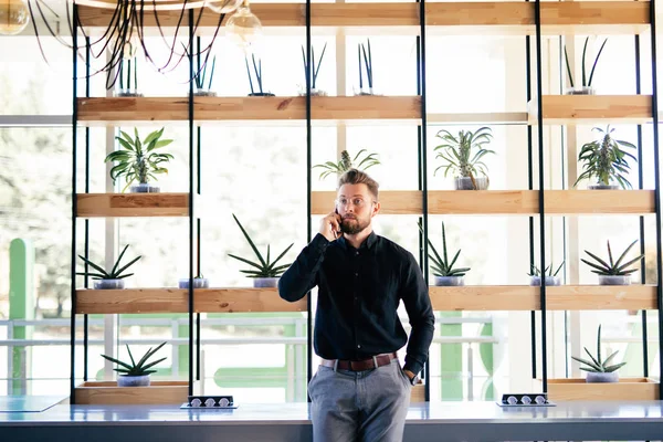 Ung skäggiga affärsman i office som pratar i mobiltelefon i moderna kontor — Stockfoto