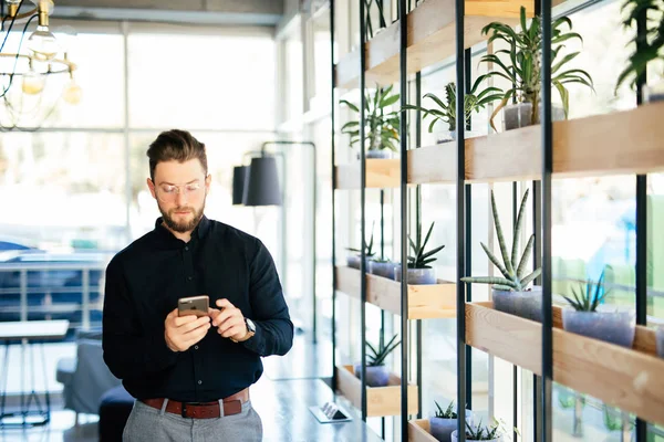 Manager i office använder app på mobiltelefonen i moderna kontorsrum — Stockfoto