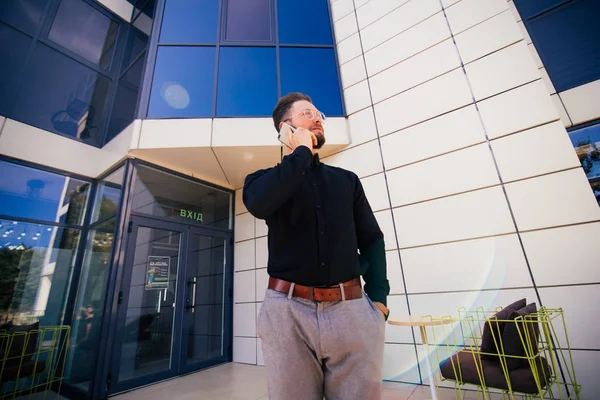 Självsäkra mannen VD som ringer med mobiltelefon, tag står i modern skyskrapa interiör. — Stockfoto