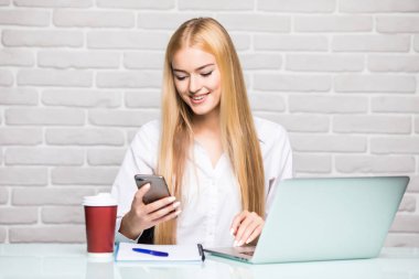 Holding ve akıllı telefon ve laptop kullanma office iş kadını