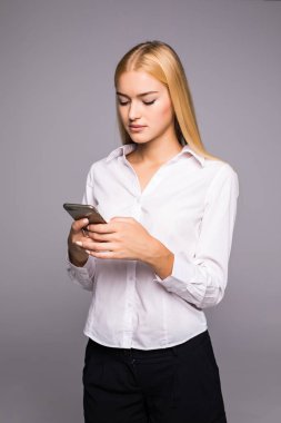 Genç kadın tipik haber smartphone. cep telefonunu kullanan güzel gülümseyen kız studio arka plan gri. İletişim kavramı