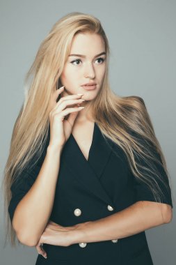 Güzellik kadını yüz portre. Güzel model. Sarışın kadın kameraya bakarak ve gri arka plan üzerinde gülümseyen.