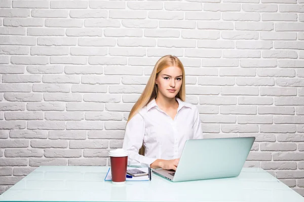 Concentrado en el trabajo. Joven hermosa mujer usando su computadora portátil mientras está sentada en la silla en su lugar de trabajo — Foto de Stock