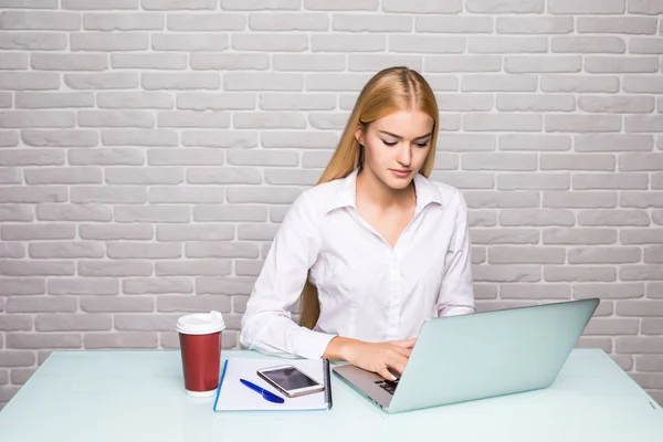 Retrato de una mujer de negocios rubia seria usando un portátil en la oficina — Foto de Stock