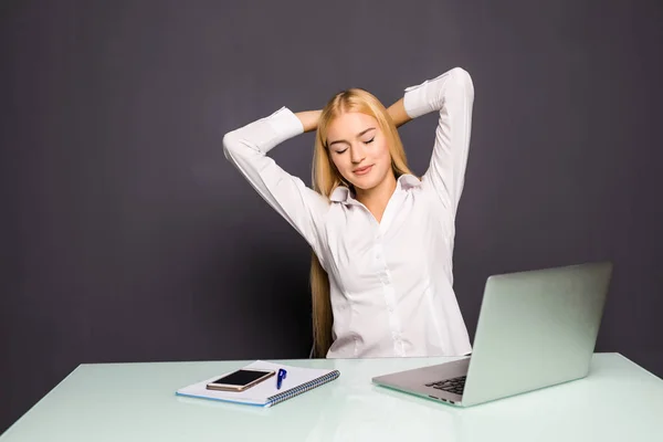 Blond affärskvinna tittar på arbete på bärbar dator med tillfredsställelse och sträcker armarna i luften. — Stockfoto
