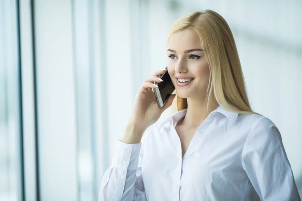 Mujer de negocios inteligente hablando por teléfono móvil en la oficina — Foto de Stock