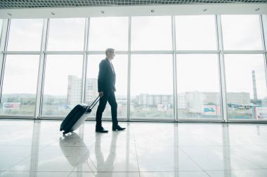 tramvay ve paket, iş seyahatleri ile yürüyüş iş adamı. İş adamı Gate terminal going için bir çanta.
