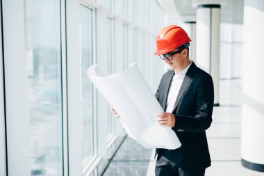 işadamı panoramik vitrinlere bakıyor planları ile inşaat kask içinde