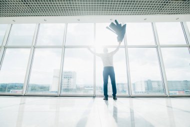Modern ofis panoramik pencerelere omuz üzerinde ceket ile genç işadamı