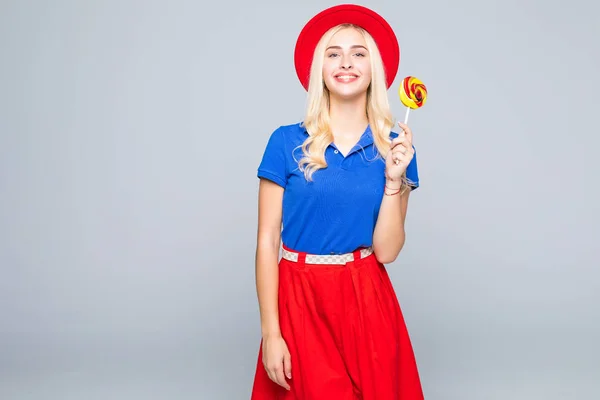 Glamourous meisje dragen van kleur kleding bedrijf lollipop op grijze achtergrond — Stockfoto
