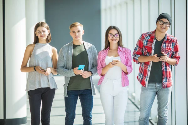 Gruppen av unga vänner tittar på sina smarta telefoner utan interagerar varandra inomhus. Begrepp av livsstil, teknik och smarta telefonen missbruk — Stockfoto