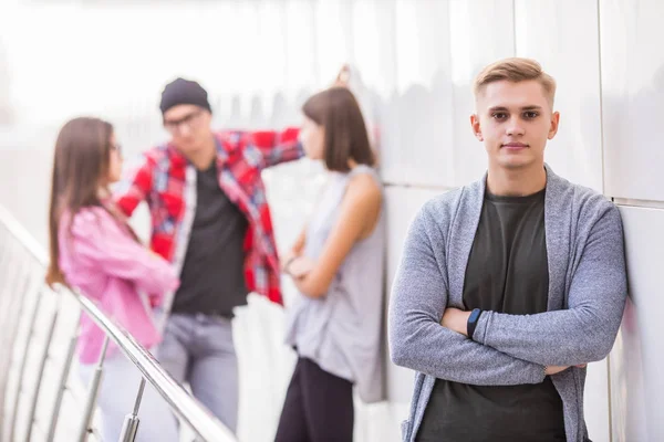 stock image Portrait of confident young man with group of people talking in background