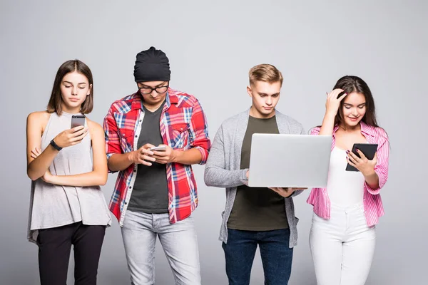 Groep van gelukkige jonge mensen zittend op de Bank en het gebruik van digitale tablet en laptop, geïsoleerd op witte achtergrond. — Stockfoto