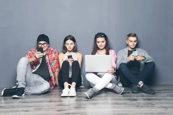 Güzel genç insan yerde otururken akıllı telefonlar kullanıyorsanız