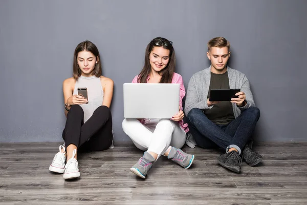 Güzel genç insanlar farklı milletlerden araçları kullanma ve gülümseyerek, beyaz duvara karşı ayakta