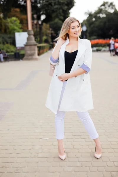 Fashion model in white jacket on stairs on street. — Stock Photo, Image