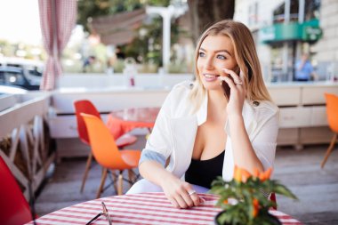 Genç, çekici bir kadın cep telefonuyla arıyor. Boş zamanlarında kafede tek başına oturuyor. Güzel gülüşlü çekici bir kadın kafede dinlenirken cep telefonuyla konuşuyor.