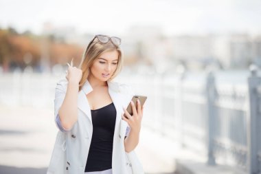 Güzel sarışın kız dolgu ile belgili tanımlık telefon, nehrin üzerinde ayakta okur mesajı.