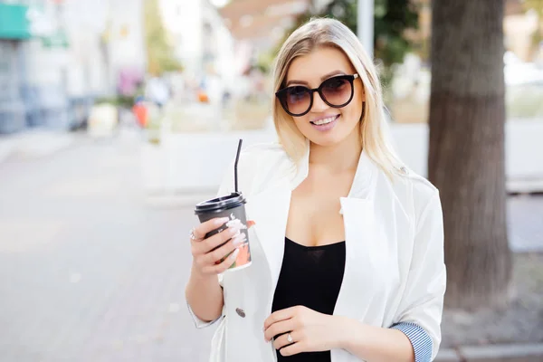 Menina bonita de pé na rua com café e óculos . — Fotografia de Stock