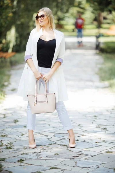 Utomhus porträtt av unga vackra glada leende kvinna, casual stil, promenader i stadsparken — Stockfoto