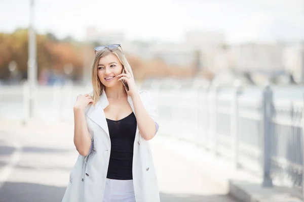 제방에 산책 시에 전화로 이야기 하는 아름 다운 젊은 여자 — 스톡 사진