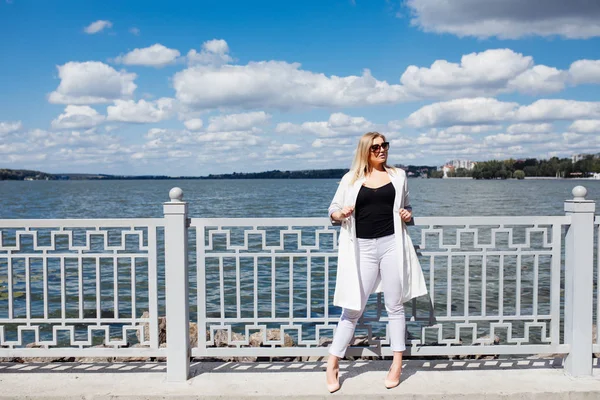 Flicka i staden. Unga vackra kvinnan koppla av på vallen, på soliga sommardag — Stockfoto