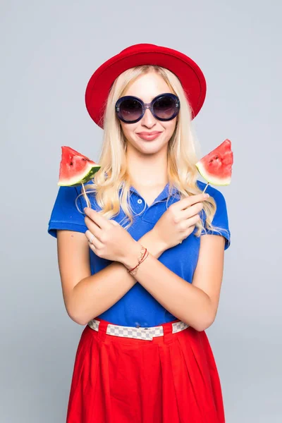 Fiatal nő nyári kalap és a színes ruhák harap lédús görögdinnye elszigetelt szürke háttér — Stock Fotó