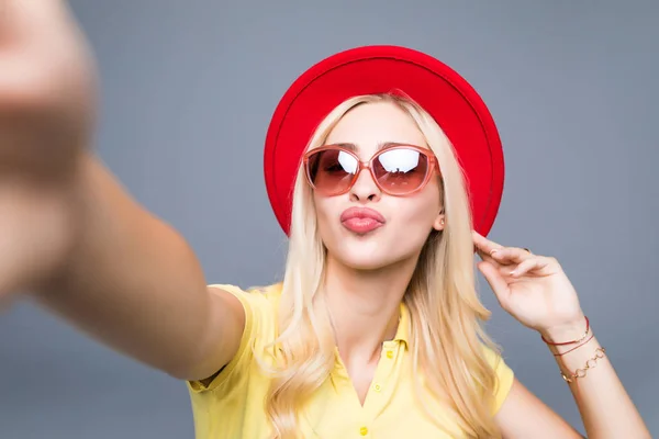 Genç güzel moda kadını kabul selfie eller telefondan gri arka plan üzerinde — Stok fotoğraf