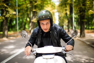 Bir yaz günü şehir sokaklarında sürme yakışıklı adam. Mutlu portre portre vintage scooter üzerinde genç erkek gülümseyen