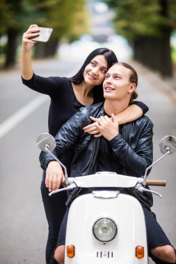 Selfie fotoğraf üzerinde smartphone açık havada yapma scooter üzerinde mutlu genç Çift