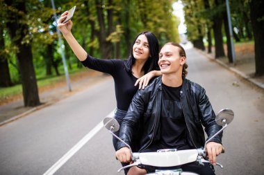Şehir içinde motosiklet üzerinde mutlu genç çift alarak selfie