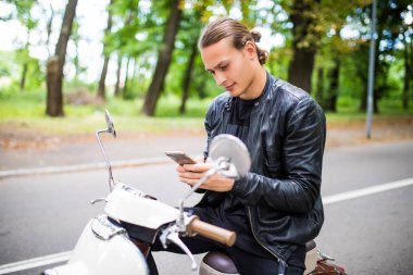 Tipik bir haber telefonda motosiklet üzerinde oturan yakışıklı adam