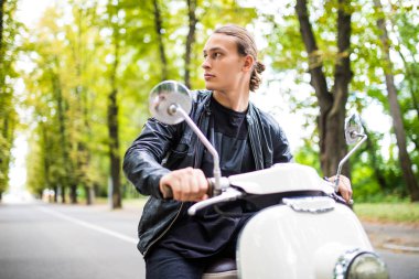 vintage bir scooter sürme ve geriye dönüp baktığımda caddenin ortasında şık genç adam