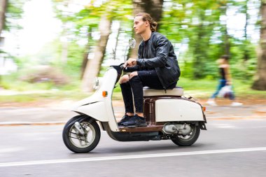 Yakışıklı bir adam bir motosiklet şehirdeki sokak hızına sürme yan görünüm