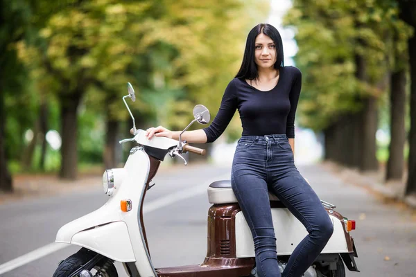 Gündelik kıyafeti scooter sokakta oturan genç moda kadın. Tatil turist kadının .