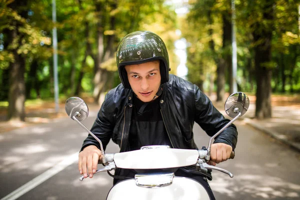 Bir yaz günü şehir sokaklarında sürme yakışıklı adam. Mutlu portre portre vintage scooter üzerinde genç erkek gülümseyen