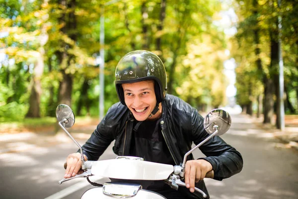 Bir yaz günü şehir sokaklarında sürme yakışıklı adam. Mutlu portre portre vintage scooter üzerinde genç erkek gülümseyen