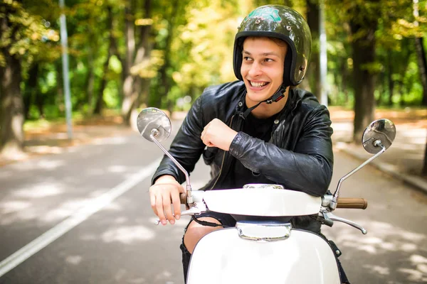 Bir yaz günü şehir sokaklarında sürme yakışıklı adam. Mutlu portre portre vintage scooter üzerinde genç erkek gülümseyen