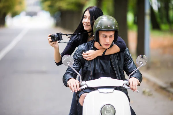 Счастливая туристическая молодая пара на скутере в новом городе. Женщина делает фото на камеру во время езды на открытом воздухе — стоковое фото