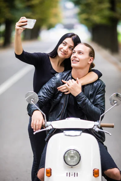 Selfie fotoğraf üzerinde smartphone açık havada yapma scooter üzerinde mutlu genç Çift