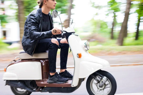 Yakışıklı bir adam bir motosiklet şehirdeki sokak hızına sürme yan görünüm