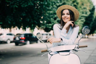 Beyaz bir t-shirt ve şapka bir scooter üzerinde poz şapkalı güzel kız