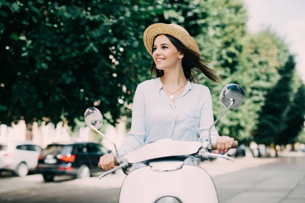 Возбужденная молодая и красивая женщина на скутере вдоль улицы и держать рот открытым — стоковое фото