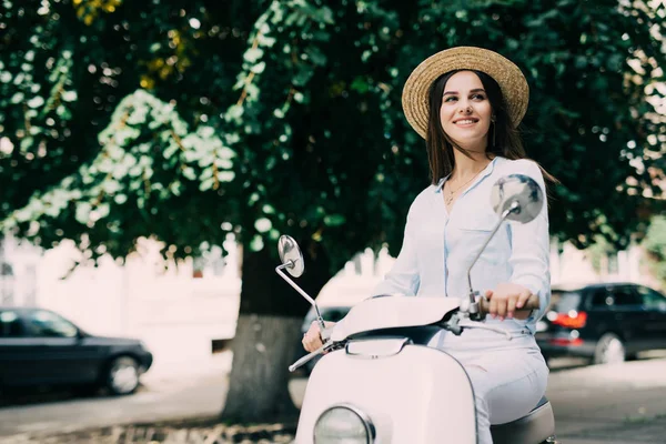 Jovem bela mulher sentada em uma scooter . — Fotografia de Stock