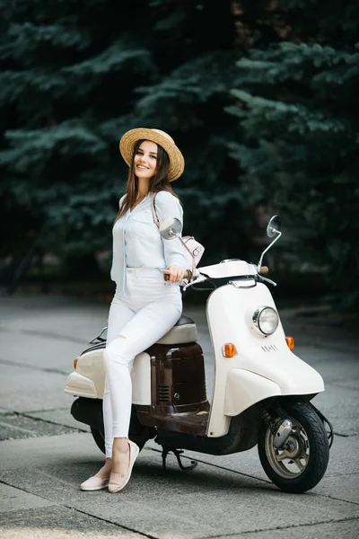 Şehir sokakta bir scooter üzerinde duran çekici kadın