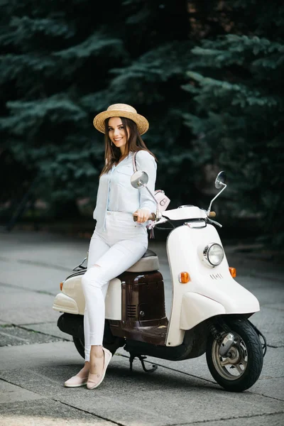 Şehir sokakta bir scooter üzerinde duran çekici kadın