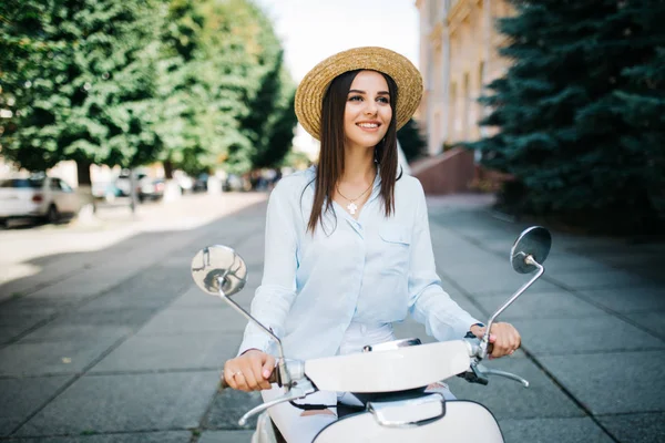 Jovem mulher em roupa casual sentado em scooter na rua . — Fotografia de Stock